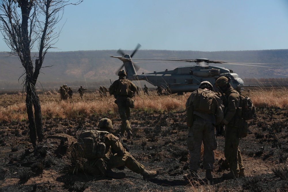 Australian soldiers and U.S. Marines air assault through a mock enemy objective