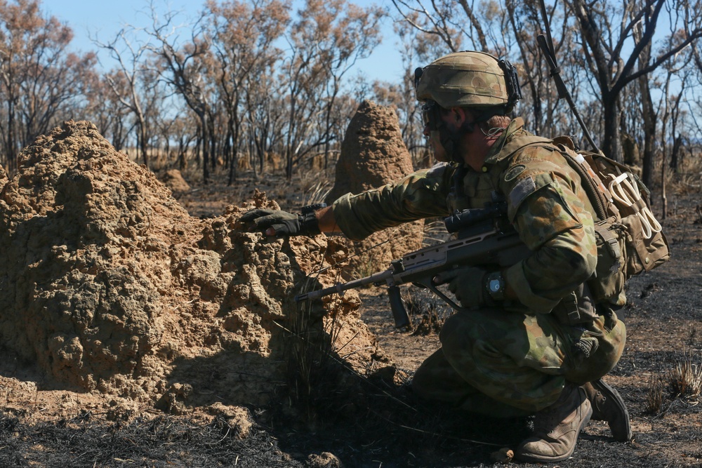 Australian soldiers and U.S. Marines air assault through a mock enemy objective