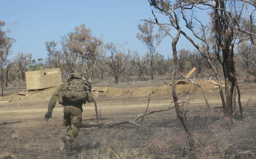 Australian soldiers and U.S. Marines air assault through a mock enemy objective