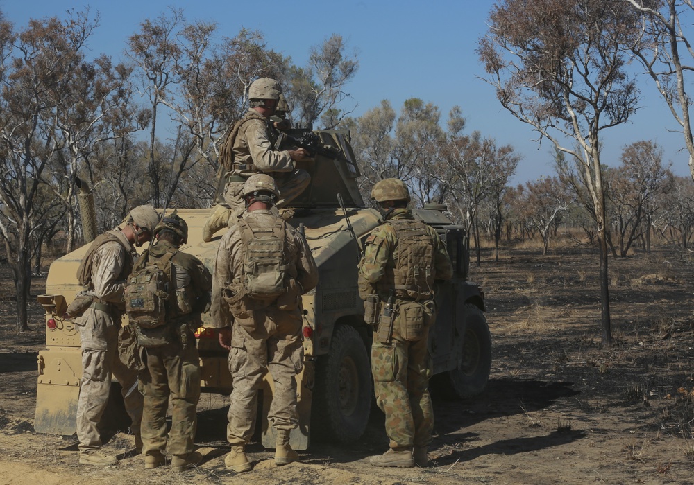 Australian soldiers and U.S. Marines air assault through a mock enemy objective