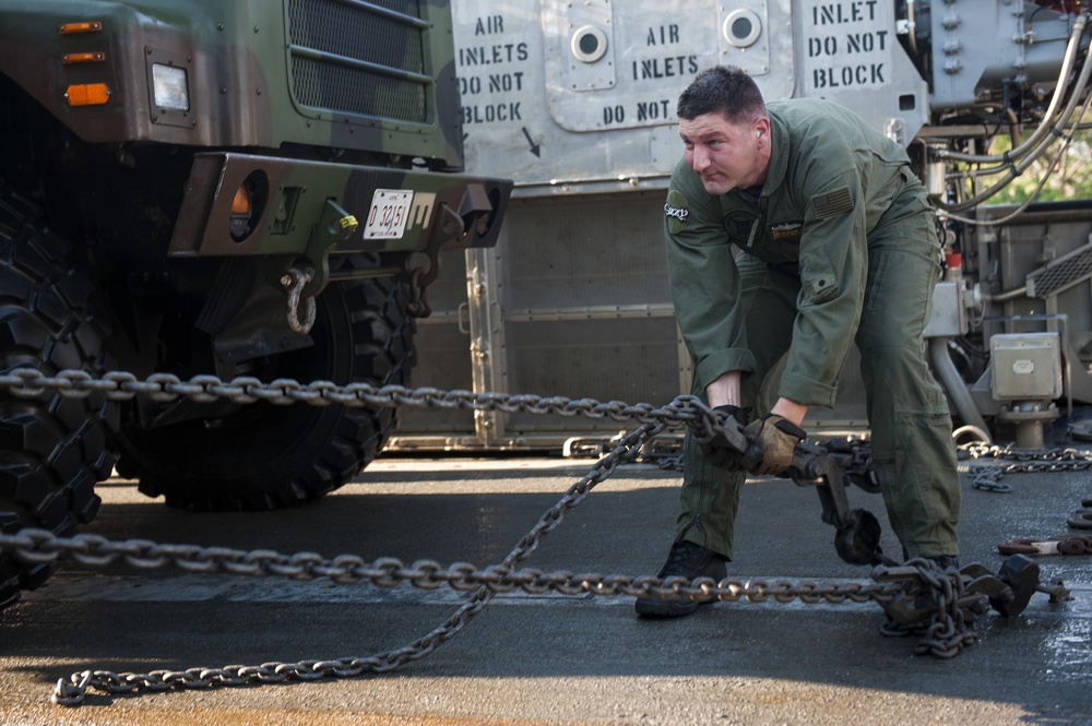 US Sailor secures equipment and cargo onto a Landing Craft Air Cushion vehicle during Talisman Sabre 2015
