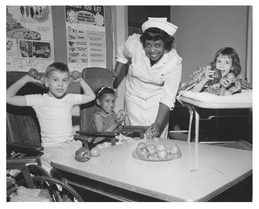 Health care workers with children and fruit