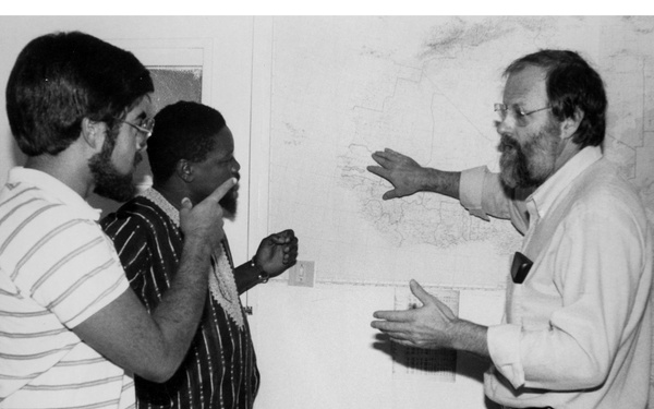 Men discussing West Africa on Map