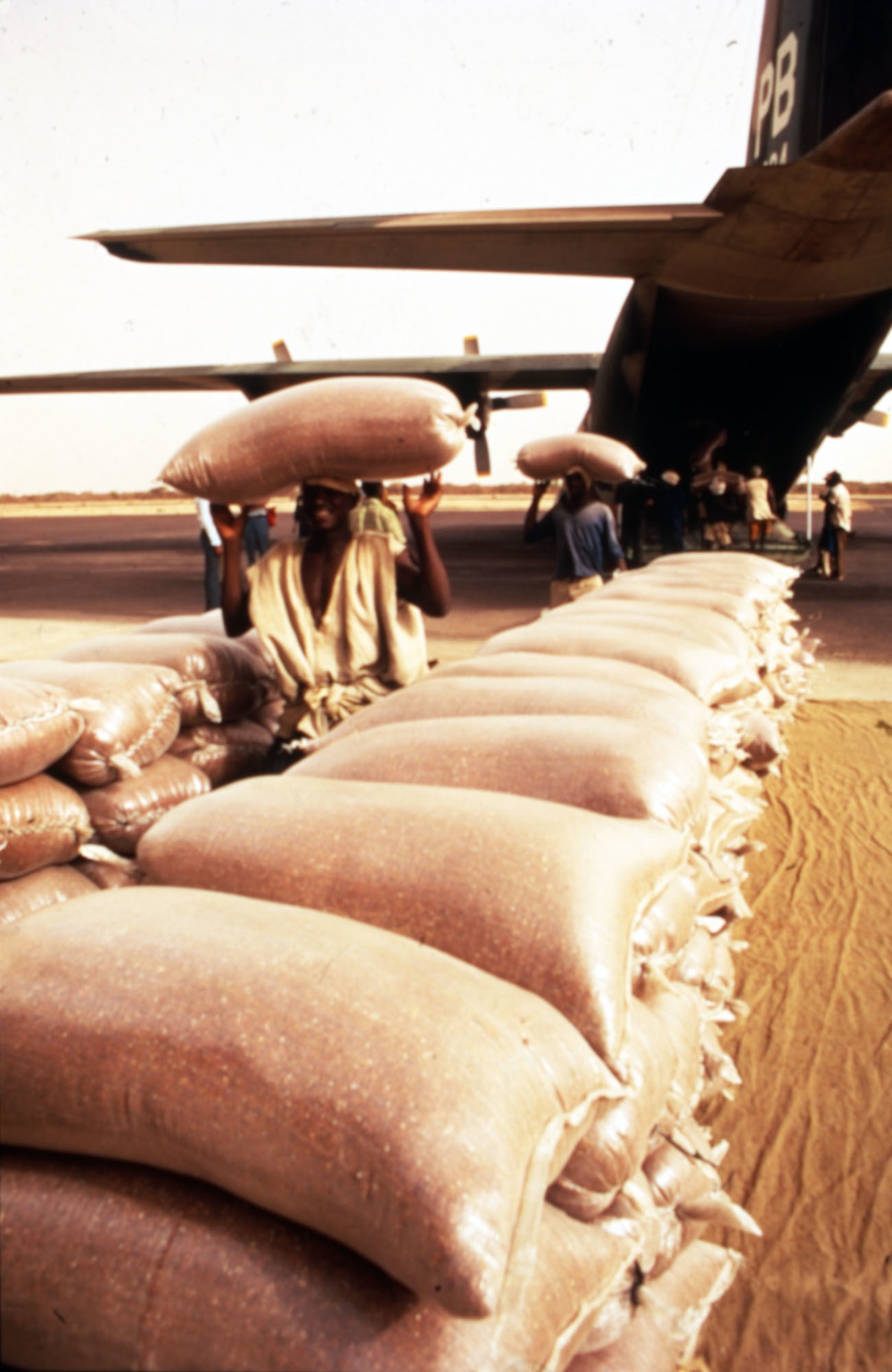 Workers unload sacks of food supplies from plane