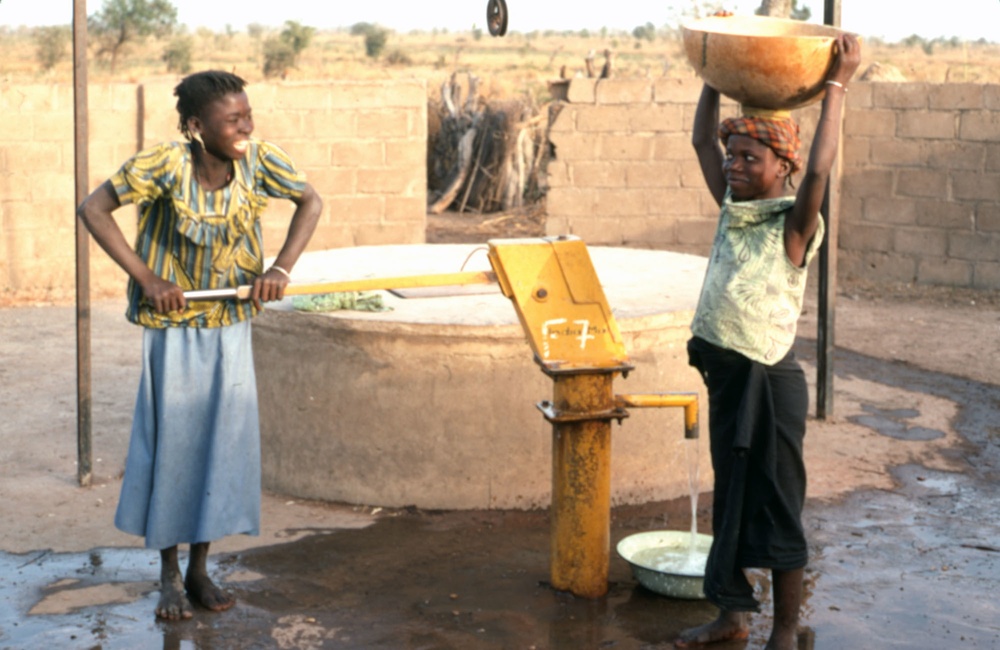 Two girls at water pump