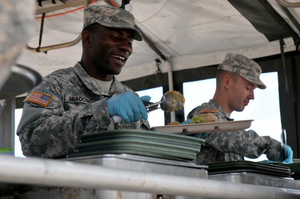 Army Reserve cook serves food and smiles during competition