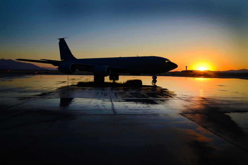 A KC-135R Stratotanker silhouetted with a reflection
