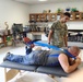 Service member provides physical therapy training to patient at IRT mission in Norwich, N.Y.