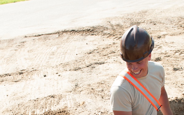 Engineer shovels dirt onto PVC pipe