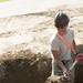 Engineer shovels dirt onto PVC pipe
