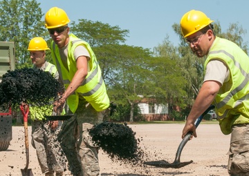 Engineers shovel asphalt