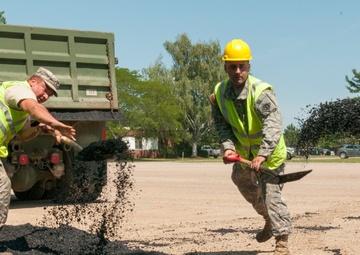 Engineers shovel asphalt