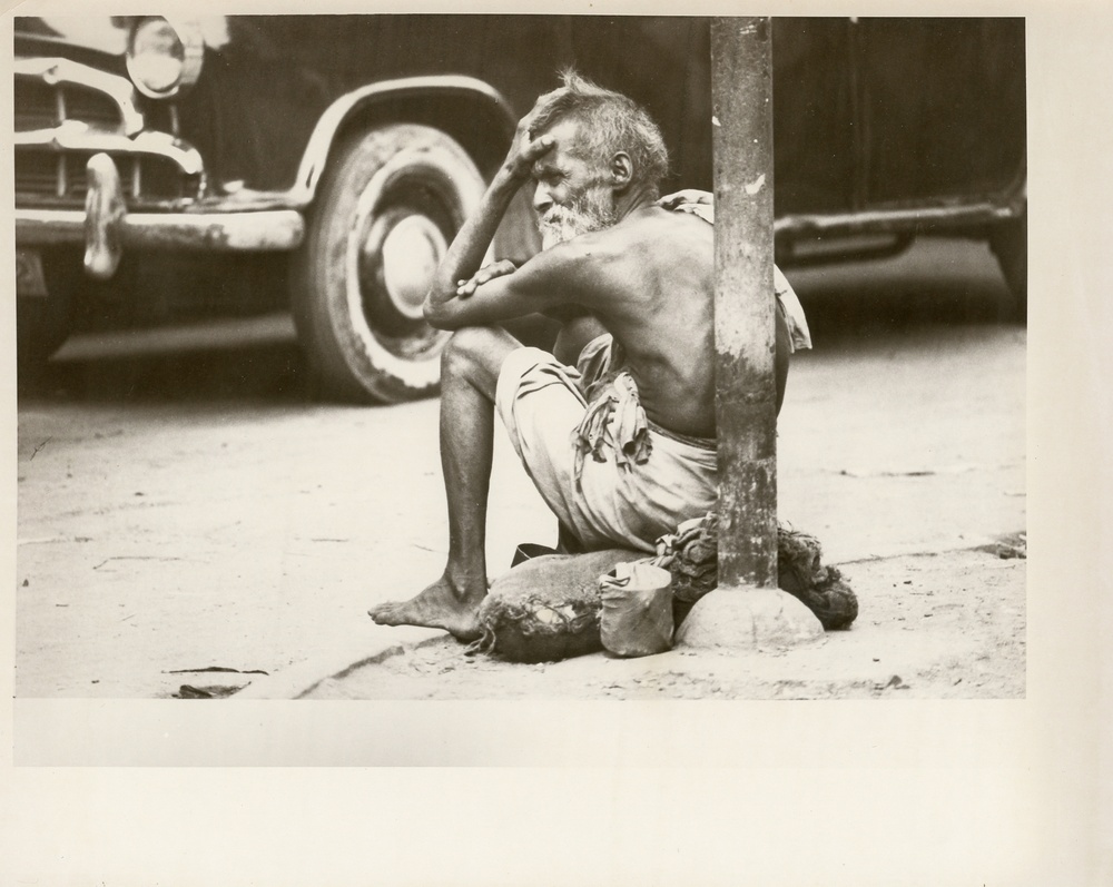Man sitting on the side of road