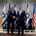 Secretary of defense and Israel's minister of defense shake hands
