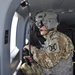 Sgt. James Bailey, crew chief with Alpha Company, 2916th Aviation Battalion with U.S. Army National Training Center Fort Irwin, stationed at Barstow-Daggett Airport, observes progress of the flight and takes pictures with his cellular phone out the side