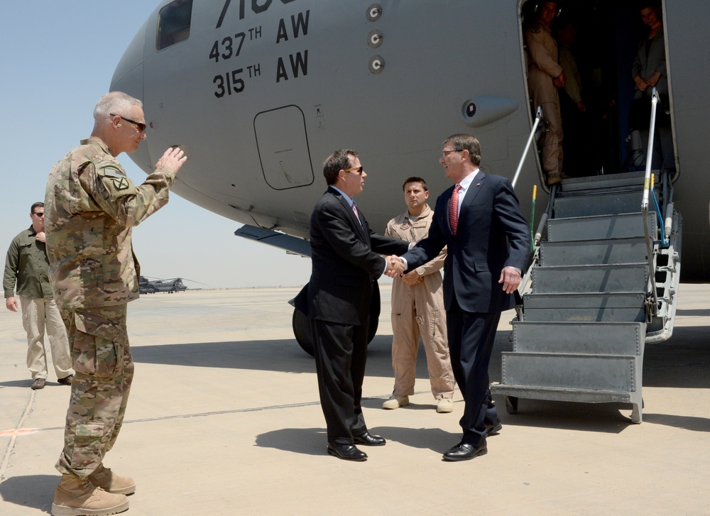 Secretary of defense is greeted by Lt. Gen. Terry and US Ambassador Stuart Jones