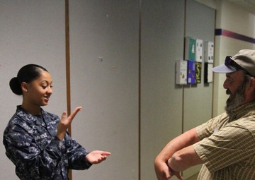 Navy hospitalman uses sign language with patient to provide care during Greater Chenango Cares IRT