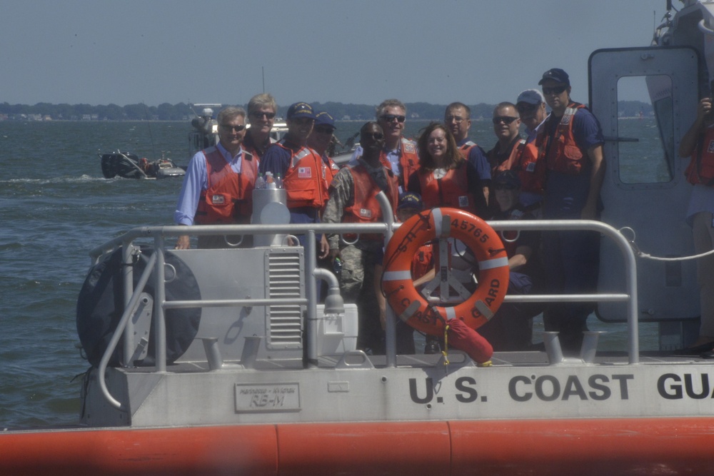 Rear Adm. Stephen P. Metruck and Gov. Terry McAuliffe stand with media and crew members