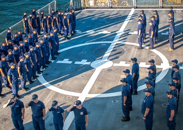 Crew members of the US Coast Guard cutter James stand at attention
