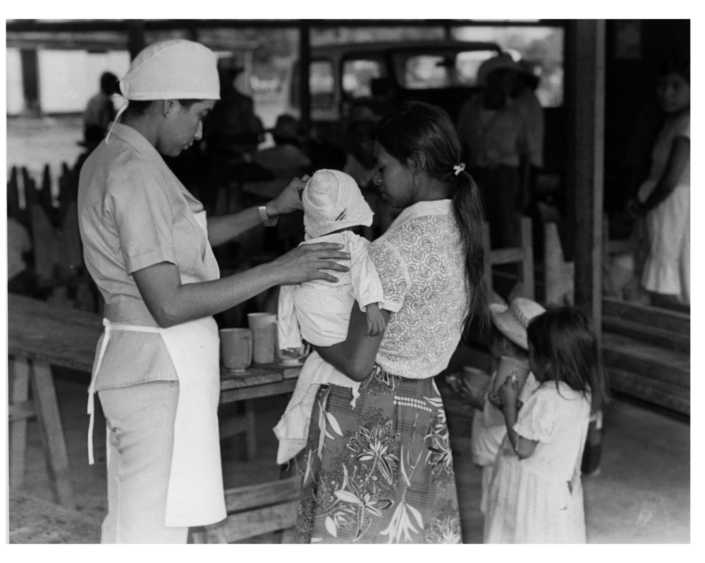 Project HOPE nurse treats baby at displaced persons settlement, Moncagua, El Salvador