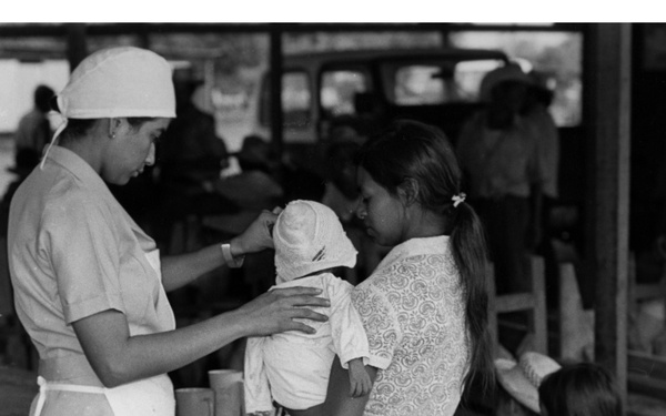 Project HOPE nurse treats baby at displaced persons settlement, Moncagua, El Salvador