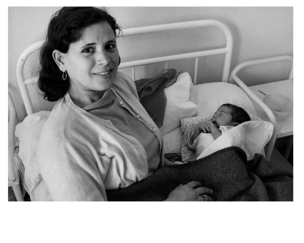 Young Tunisian woman holds her newborn baby in maternity ward - Bizerte, Tunisia