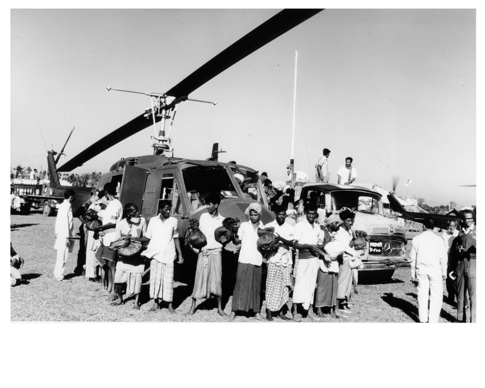 East Pakistanis loading American helicopter with disaster relief rice supplies