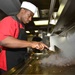 USS Forrest Sherman Sailor prepares food in the galley