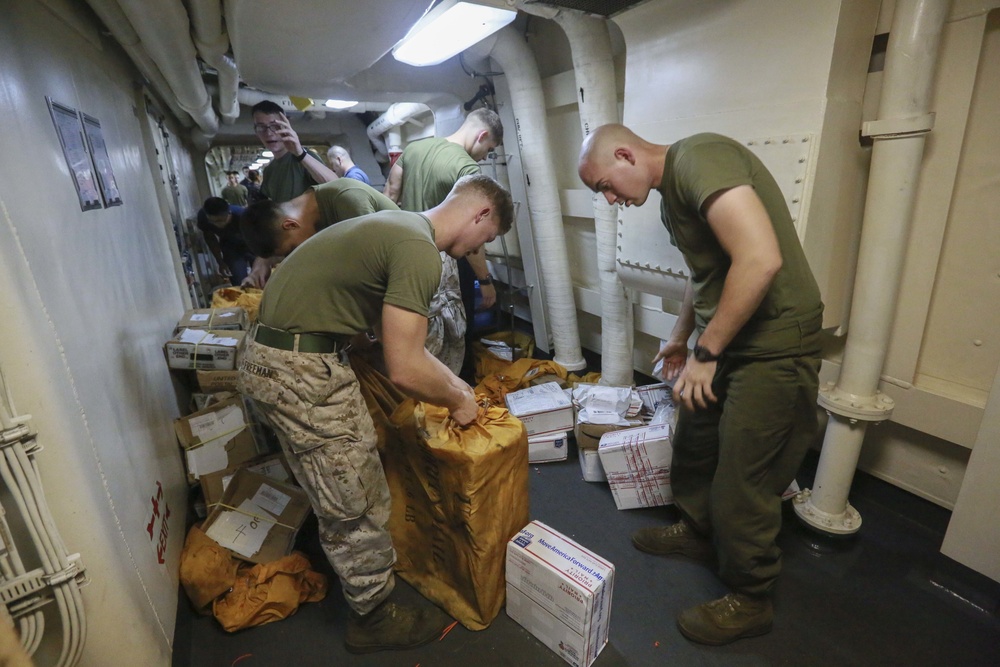 Mail call: U.S. Marines and Sailors sort packages