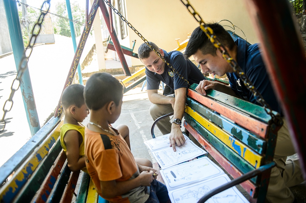 Service members from USNS Mercy play with Vietnamese children during Pacific Partnership 2015