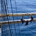 Coast Guard Eagle crew members repair damaged sails