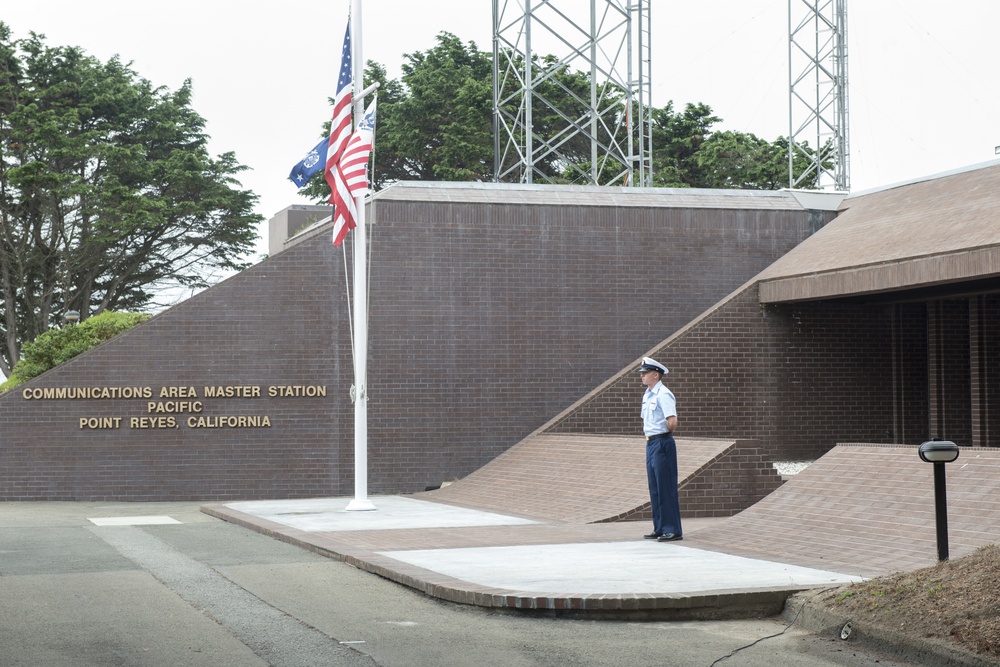 Fireman Ellington Crevier waits by the flagpole at the Communication Area Master Station Pacific