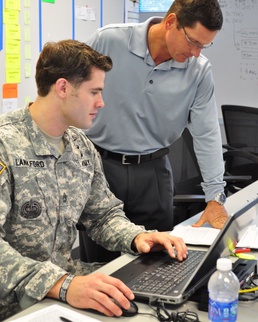 U.S. Army Sgt. 1st Class reviews coursework with instructor