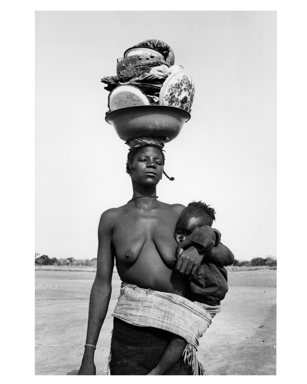 Woman with Child Carrying Cookware on Head