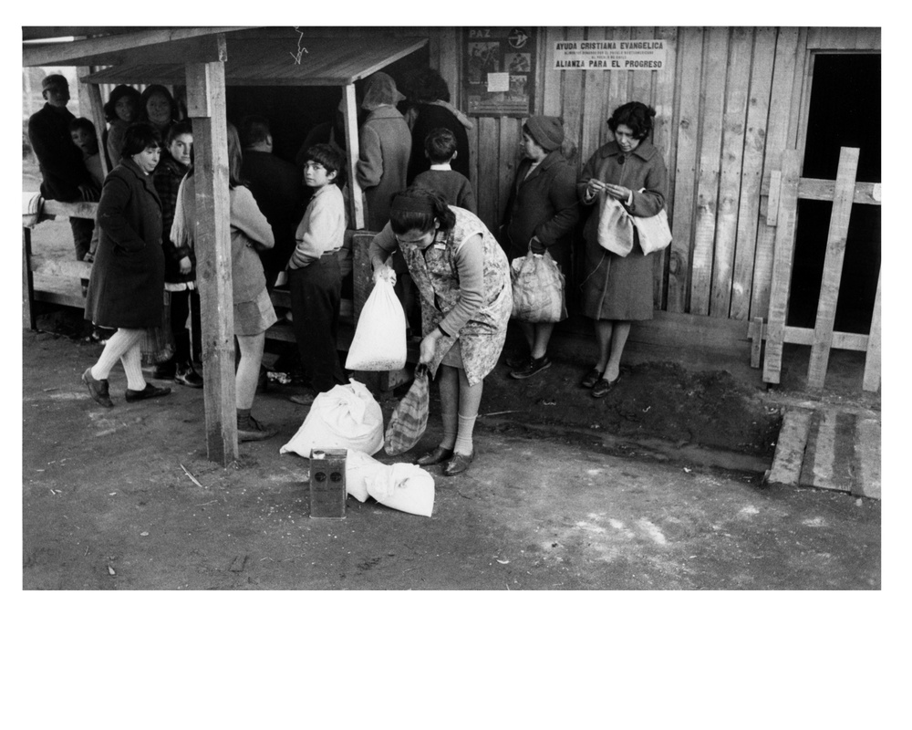 Residents of Chepe Hill pick up the American surplus food, which they receive as payment for their labor on the housing project - Chile