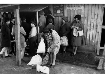 Residents of Chepe Hill pick up the American surplus food, which they receive as payment for their labor on the housing project - Chile