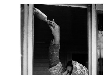 A Chilean housewife paints the new house which she will soon move into - Chile