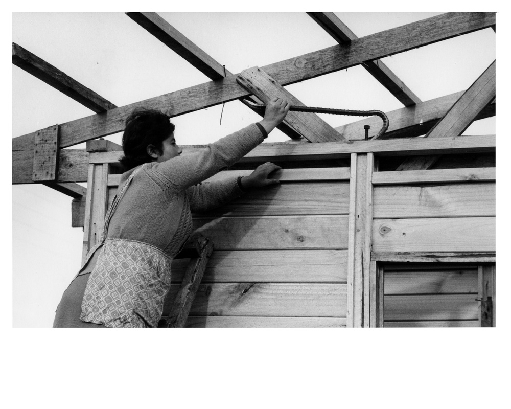 A Chilean housewife wields a crowbar as she works on new house which she and her family will soon move into - Chile