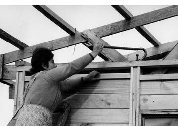 A Chilean housewife wields a crowbar as she works on new house which she and her family will soon move into - Chile