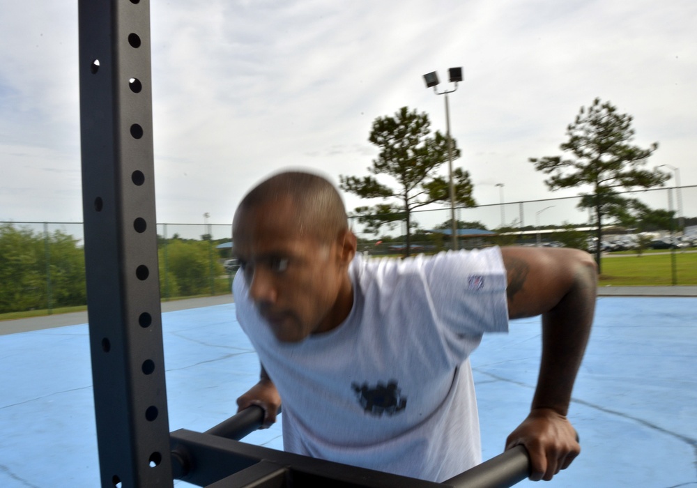 Petty Officer 1st Class Raymond Concepcion demonstrates workout