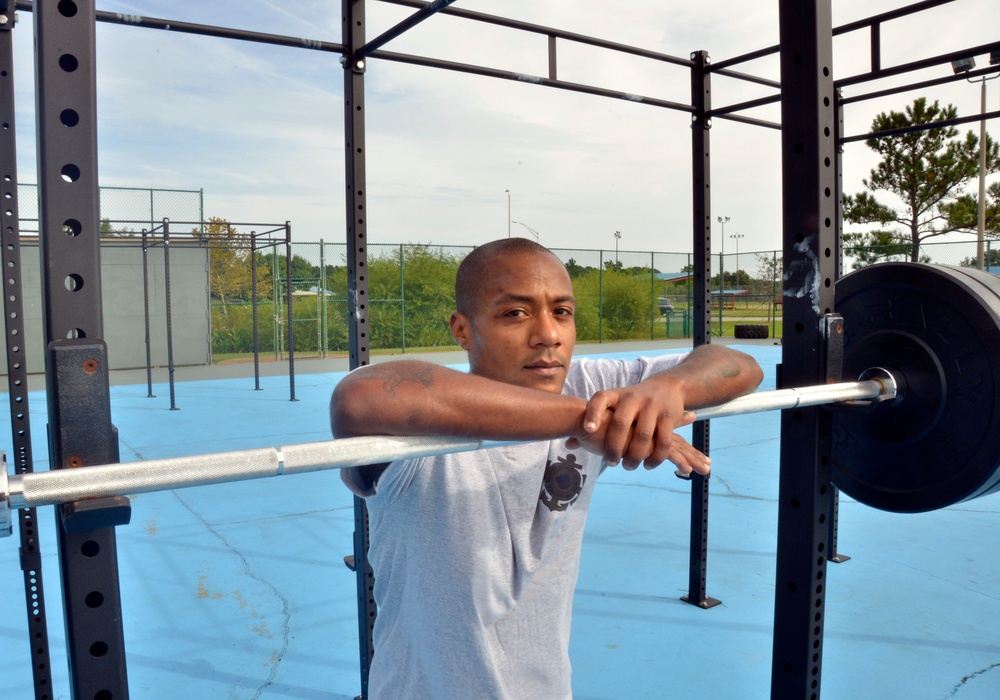 Petty Officer 1st Class Raymond Concepcion demonstrates workout