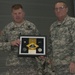 Outgoing battalion commander receives gift from command sergeant major