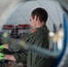 Petty Officer 2nd Class Troy Campbell tightens bolts on a helicopter air conditioning unit