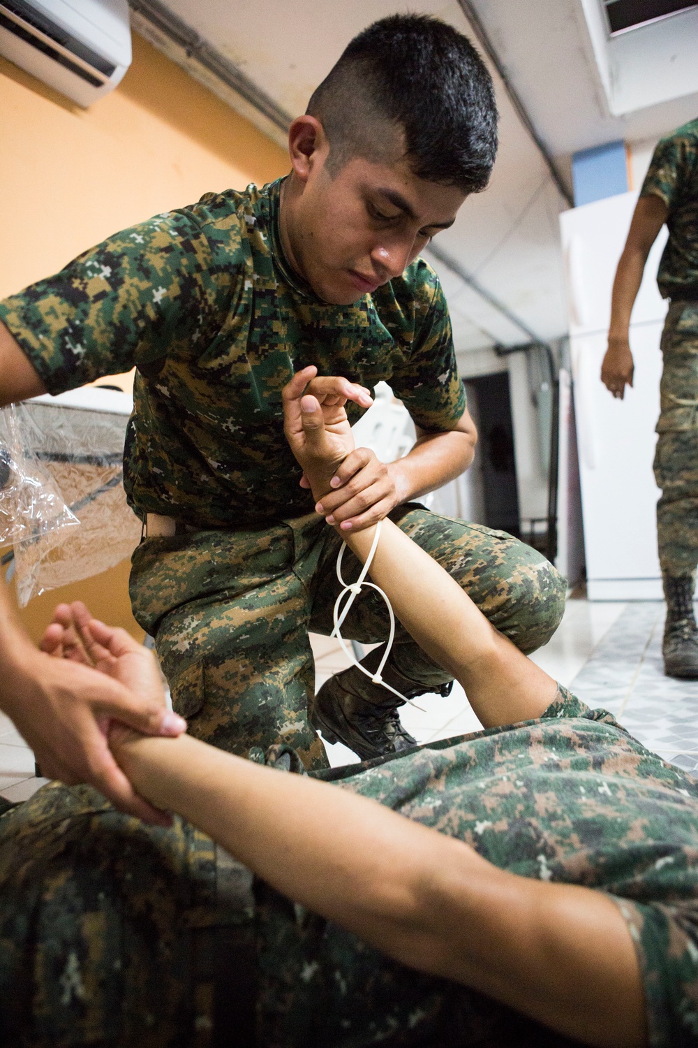 U.S. Marines with SCT-Guatemala, SPMAGTF-SC, teach the Brigada de Infanteria Marina handcuffing techniques