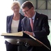 Secretary of defense signs a guest book while Italian Defense Minister Roberta Pinotti looks over his shoulder