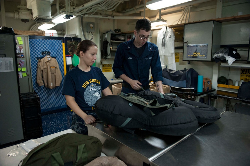 USS Essex Sailors perform maintenance on life preservers