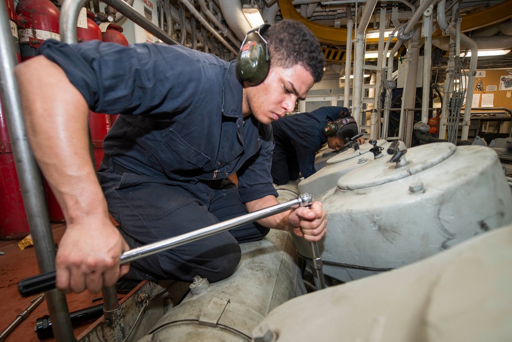 USS Rushmore Sailors work on a main propulsion diesel engine