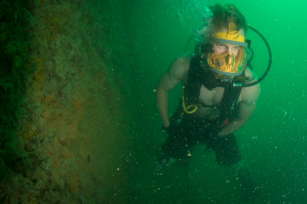 Navy divers inspect a pier in Bahrain