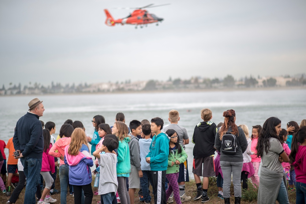 A Coast Guard Air Station San Francisco helicopter aircrew performs a demonstration for elementary school students