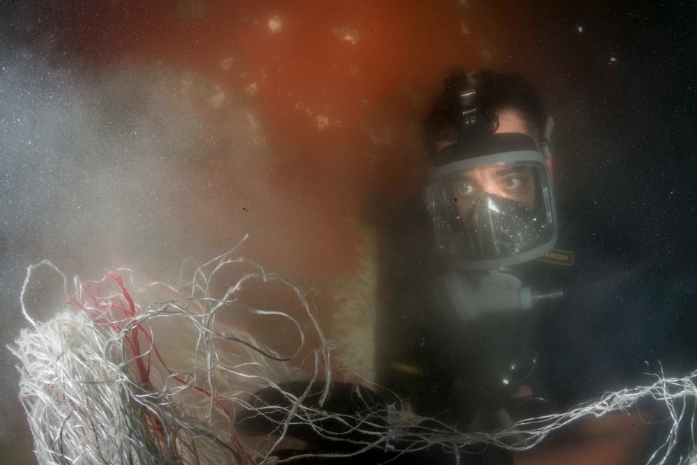 Navy diver removes tangled line from ship in Bahrain